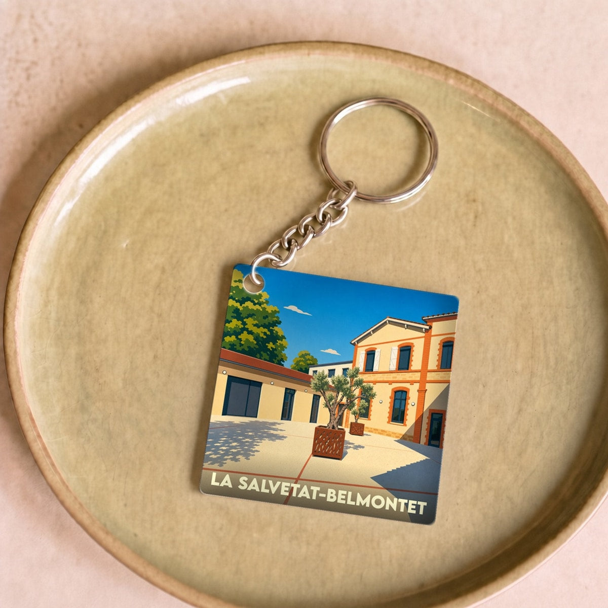 Porte-clés souvenir de la ville de La Salvetat-Belmontet avec une illustration stylisée.
