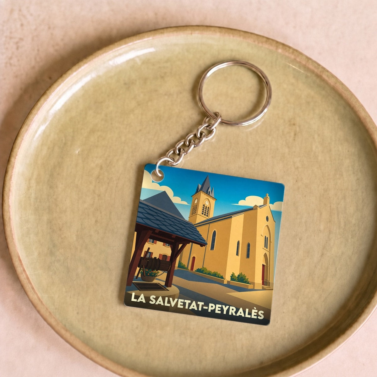 Porte-clés souvenir de la ville de La Salvetat-Peyralès avec une illustration stylisée.
