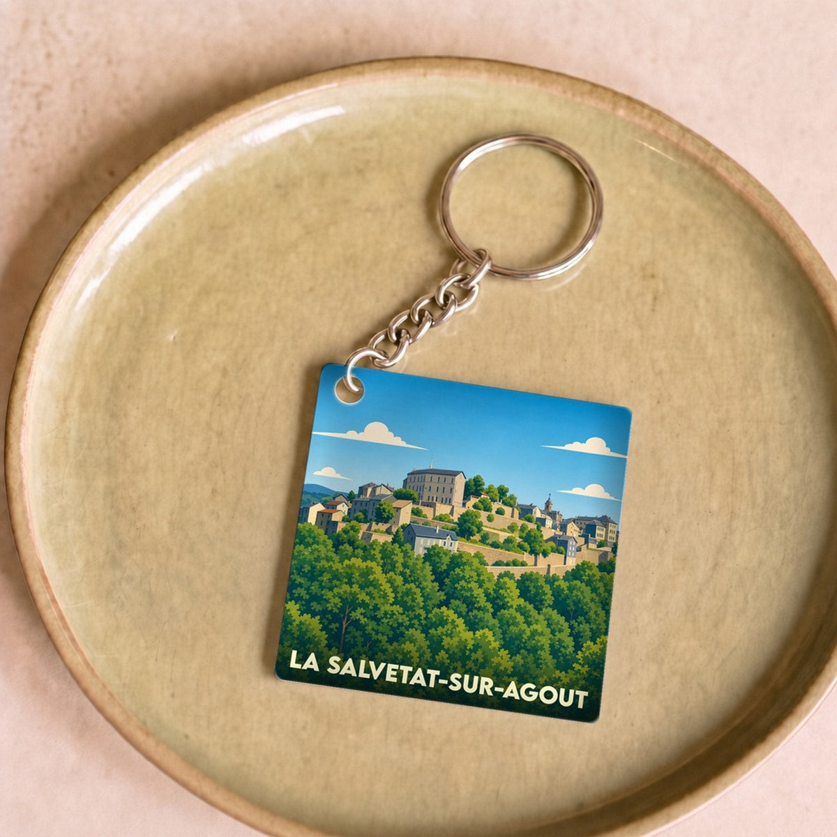 Porte-clés souvenir de la ville de La Salvetat-sur-Agout avec une illustration stylisée.