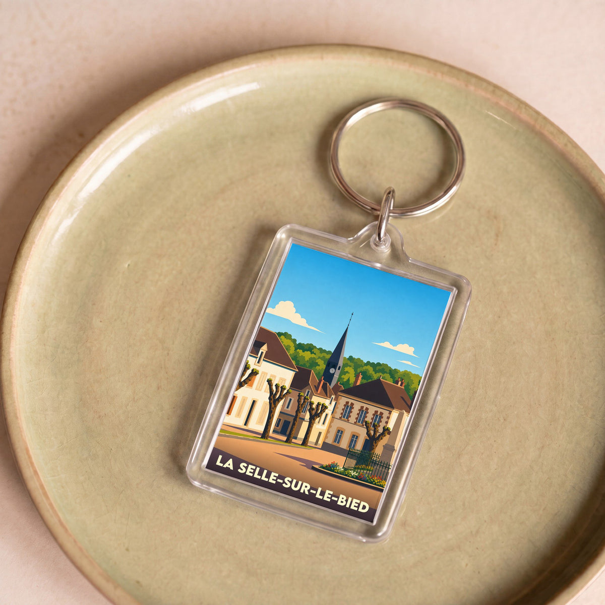 Porte-clés souvenir de la ville de La Selle-sur-le-Bied avec une illustration stylisée.