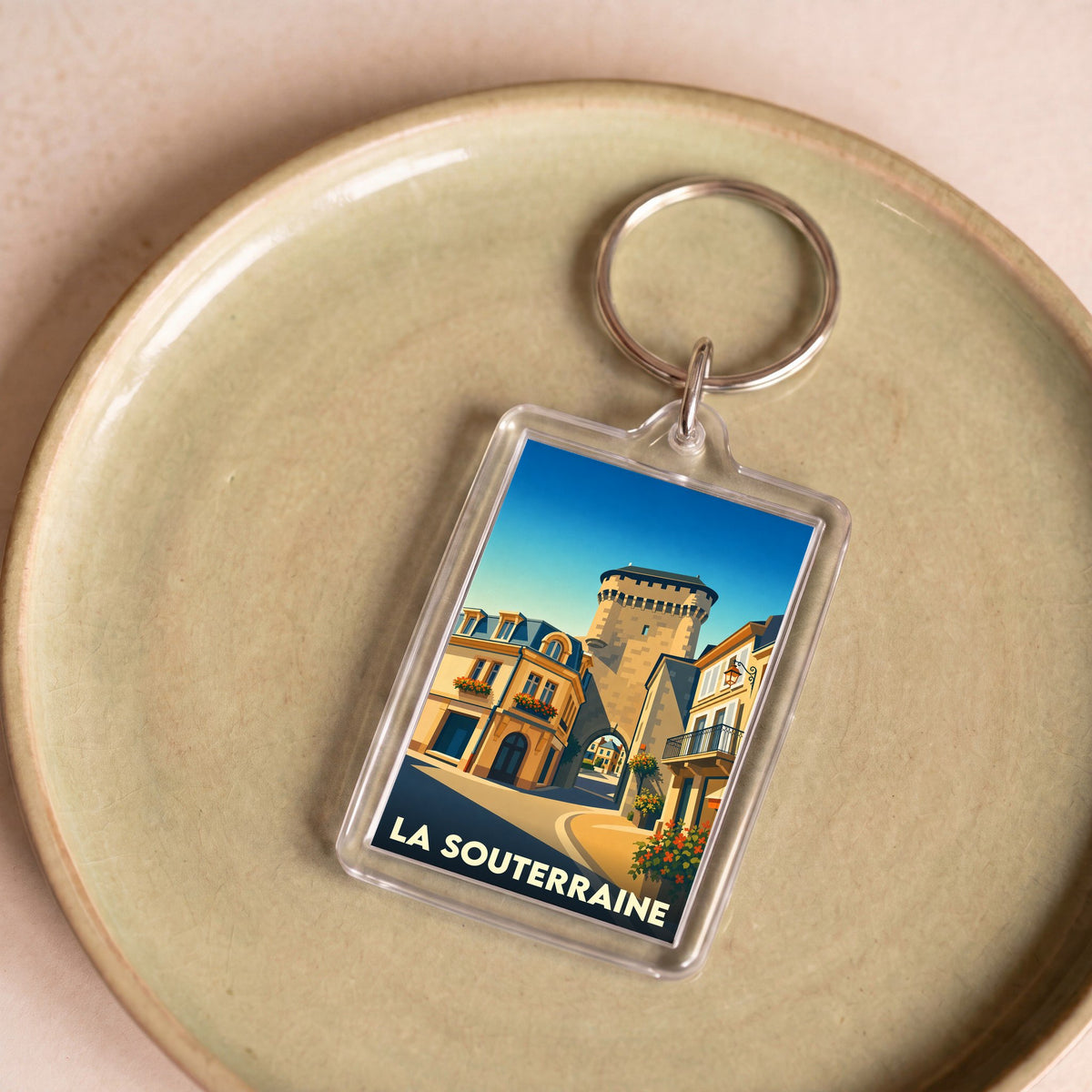 Porte-clés souvenir de la ville de La Souterraine avec une illustration stylisée de sa porte médiévale.
