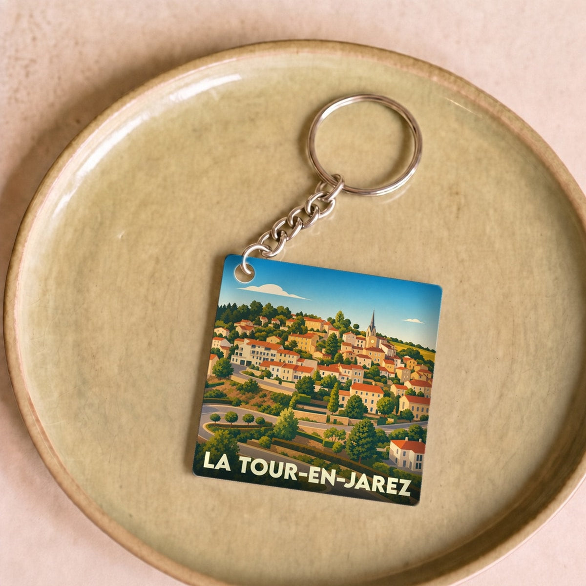 Porte-clés souvenir de la ville de La Tour-en-Jarez avec une illustration stylisée.