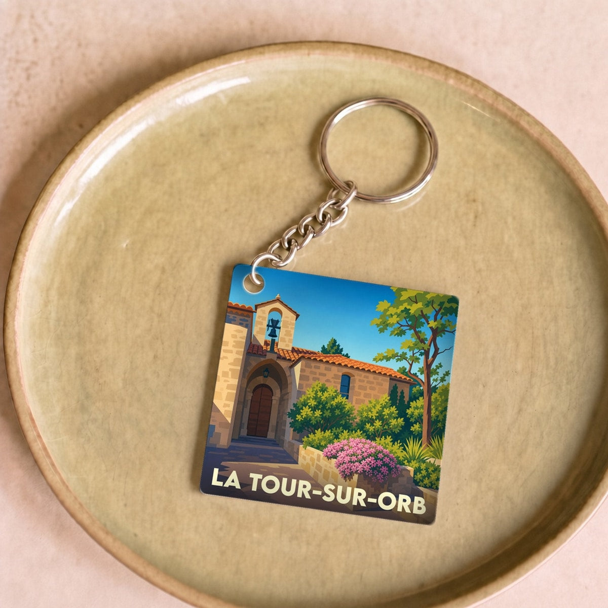 Porte-clés souvenir de la ville de La Tour-sur-Orb avec une illustration stylisée.
