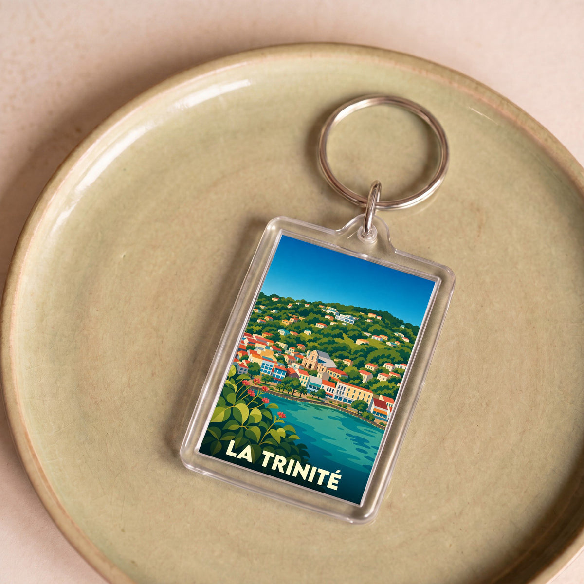 Porte-clés souvenir de la ville de La Trinité avec une illustration stylisée.