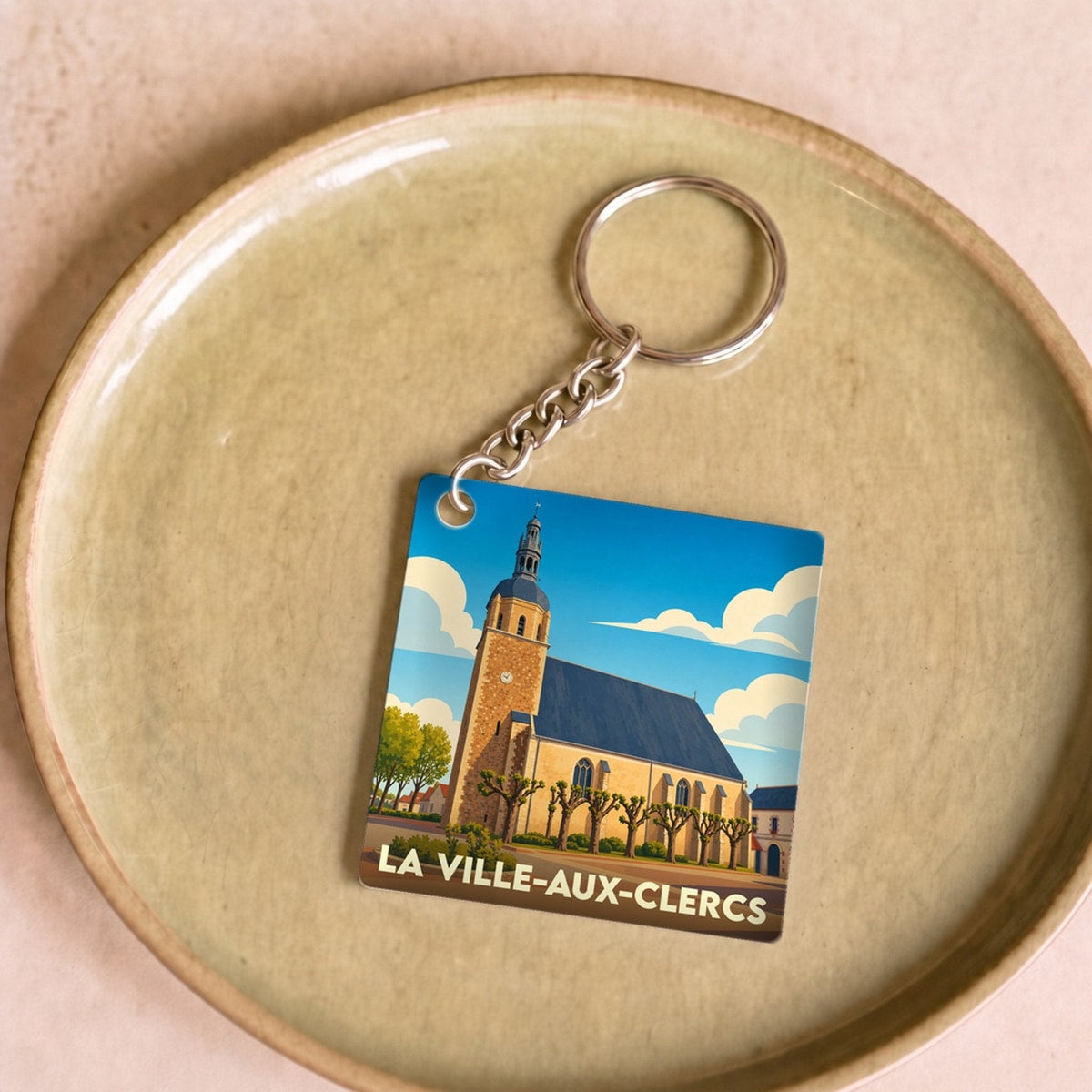 Porte-clés souvenir de La Ville-aux-Clercs avec une illustration stylisée de son église.