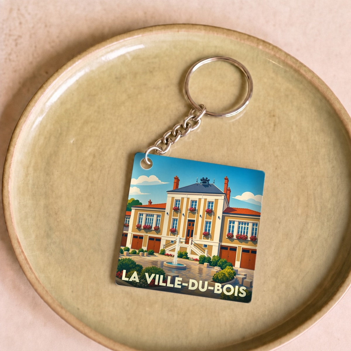 Porte-clés souvenir de la ville de La Ville-du-Bois avec une illustration stylisée de sa mairie.