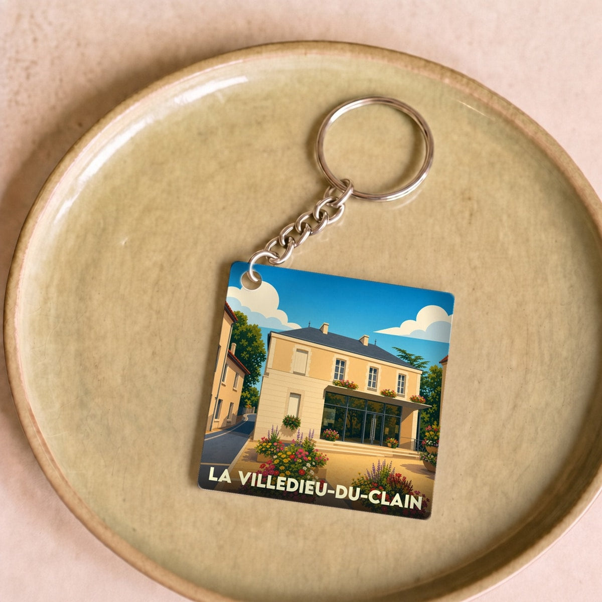 Porte-clés souvenir de la ville de La Villedieu-du-Clain avec une illustration stylisée.