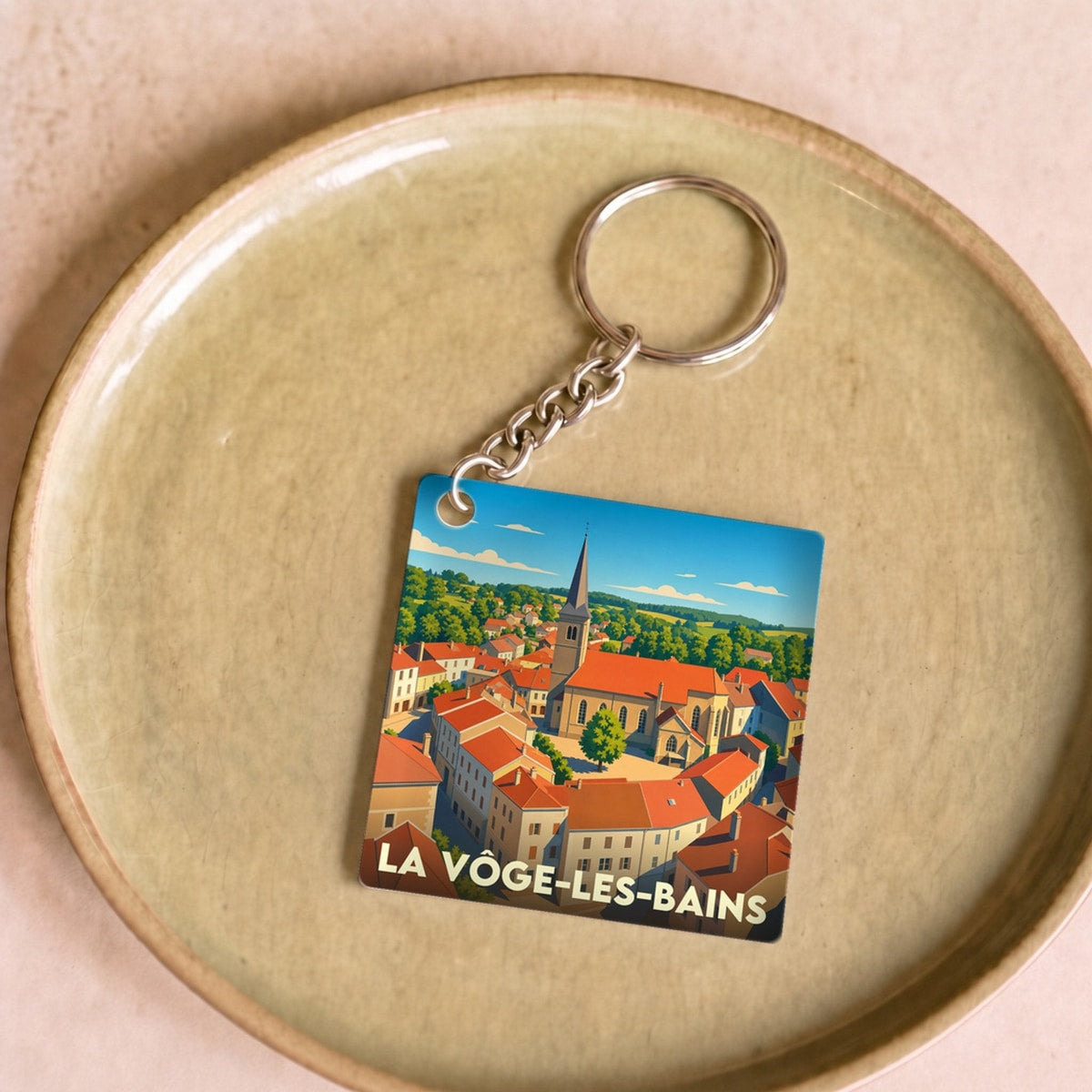 Porte-clés souvenir de la ville de La Vôge-les-Bains avec une illustration stylisée.
