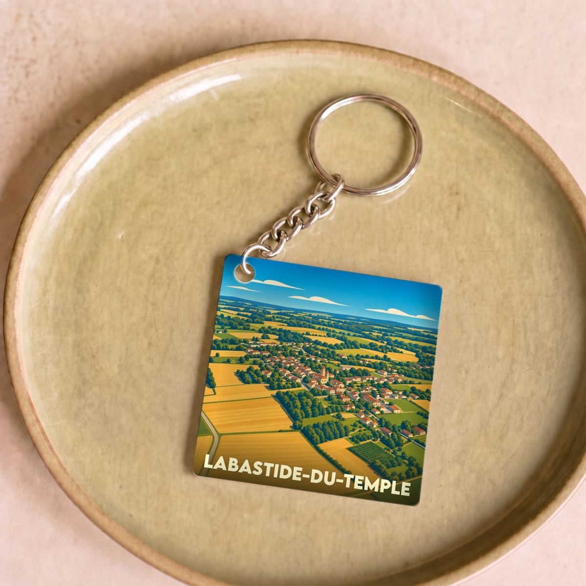 Porte-clés souvenir de la ville de Labastide-du-Temple avec une illustration aérienne et stylisée de ses paysages.