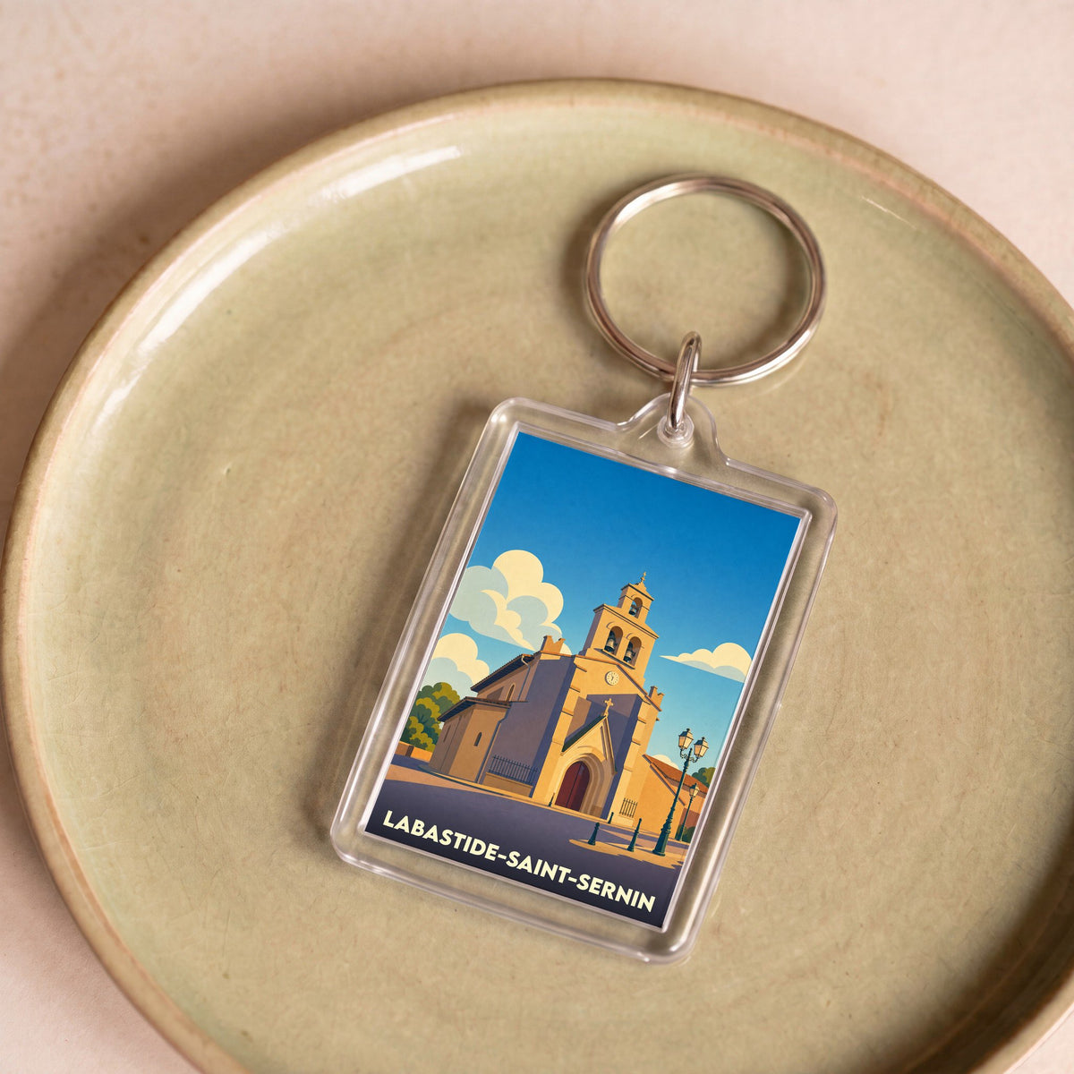 Porte-clés souvenir de la ville de Labastide-Saint-Sernin avec une illustration stylisée de son église.