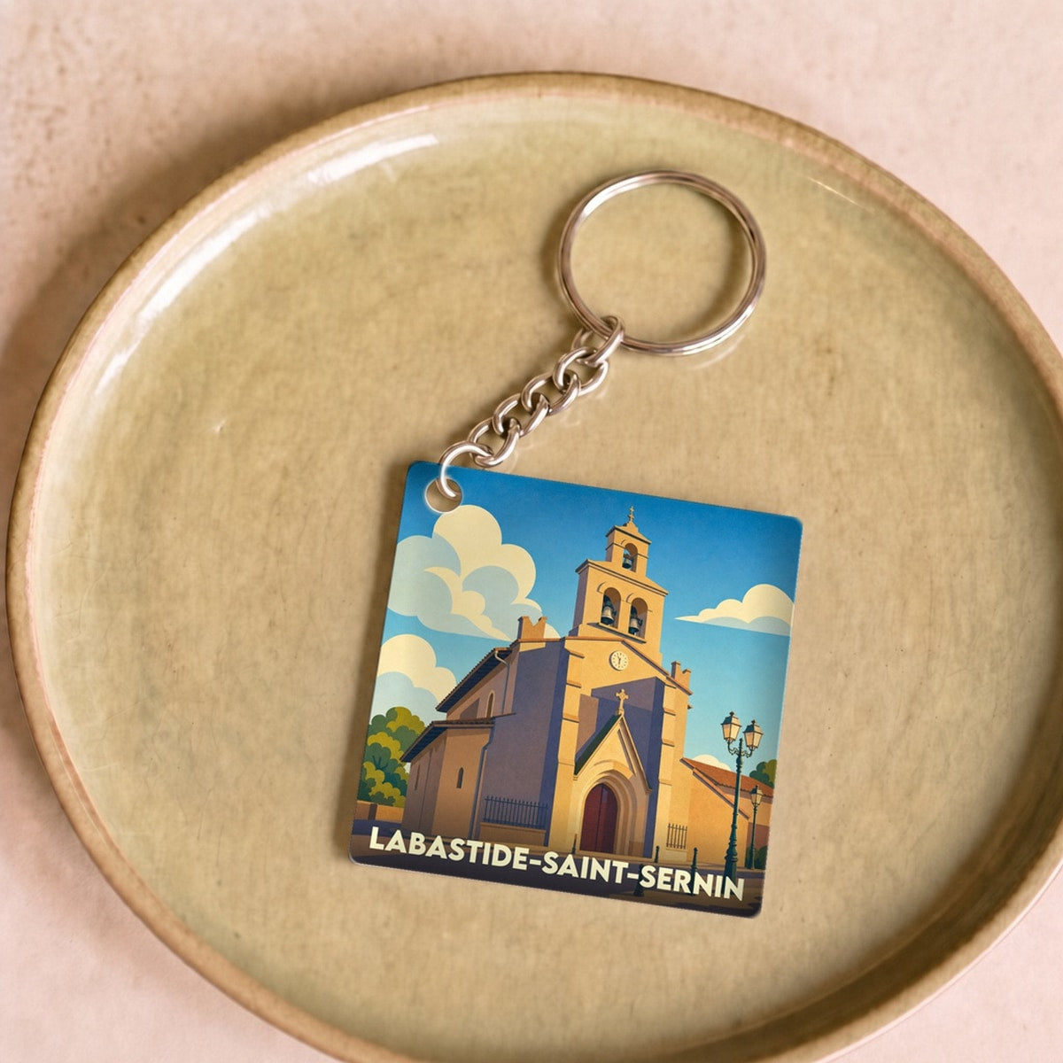 Porte-clés souvenir de la ville de Labastide-Saint-Sernin avec une illustration stylisée de son église.