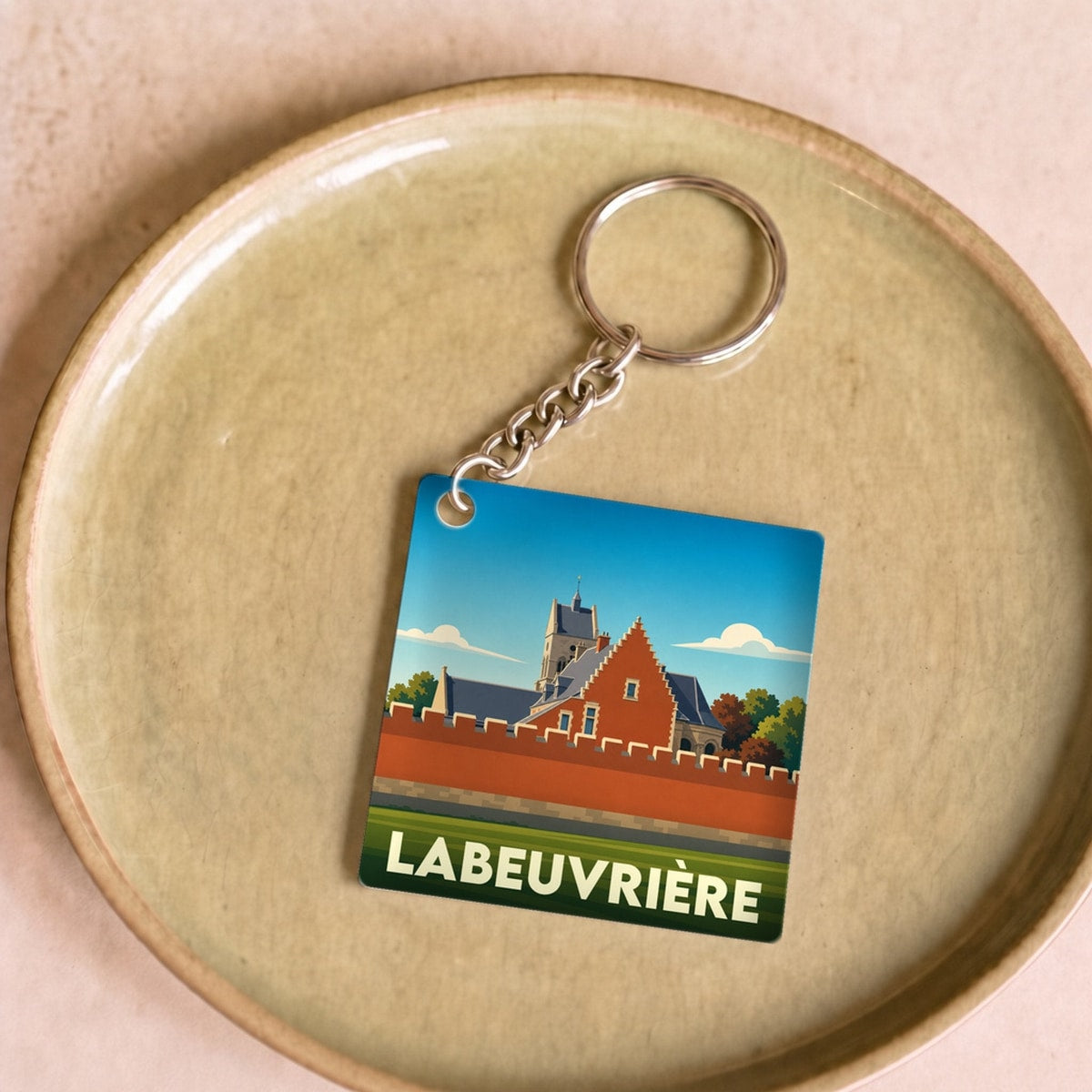 Porte-clés souvenir de la ville de Labeuvrière avec une illustration stylisée.