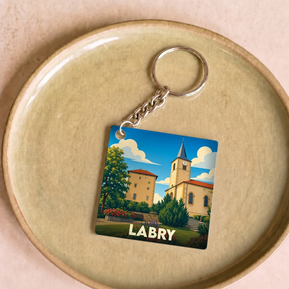Porte-clés souvenir de la ville de Labry avec une illustration stylisée de son église et de son château.