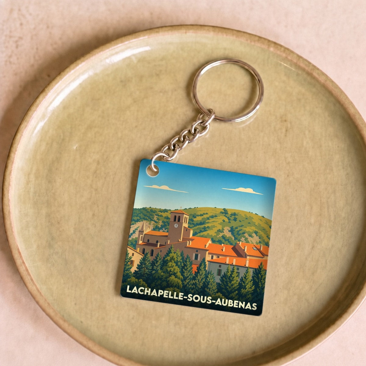 Porte-clés souvenir de la ville de Lachapelle-sous-Aubenas avec une illustration stylisée.