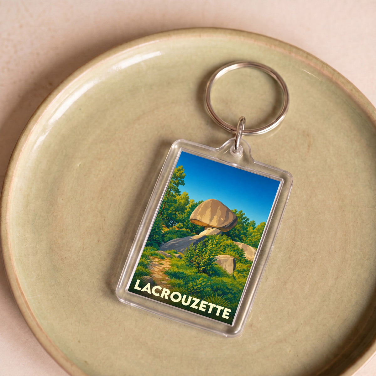 Porte-clés souvenir de la ville de Lacrouzette avec une illustration stylisée du Peyro Clabado.