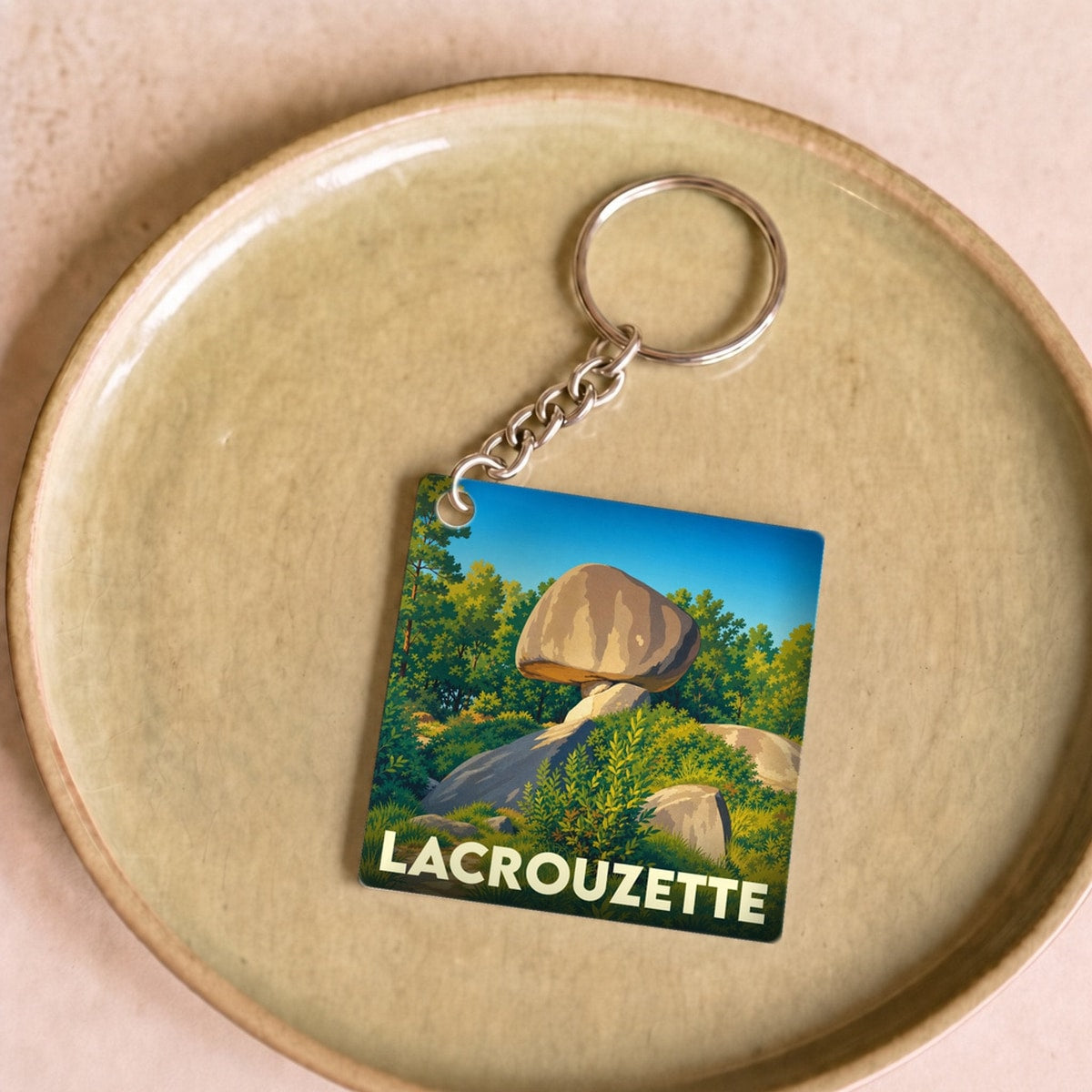 Porte-clés souvenir de la ville de Lacrouzette avec une illustration stylisée du Peyro Clabado.