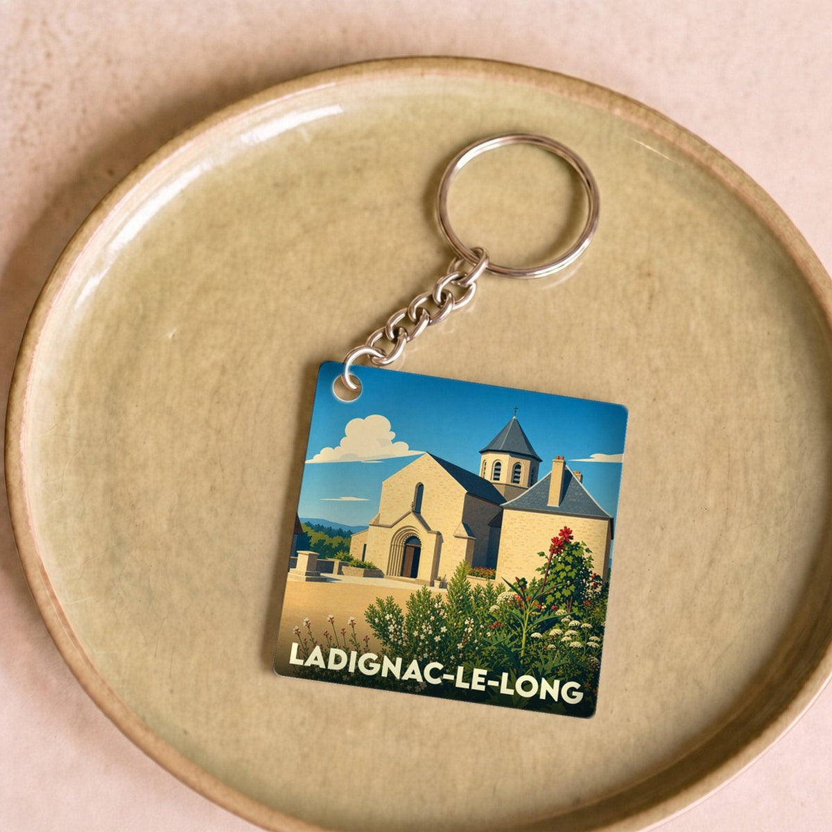 Porte-clés souvenir de la ville de Ladignac-le-Long avec une illustration stylisée de son église.