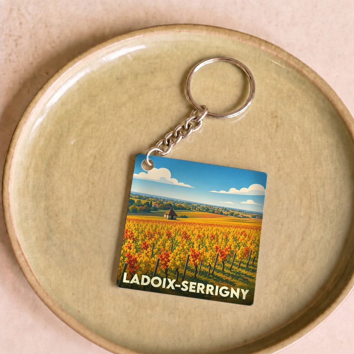 Porte-clés souvenir de la ville de Ladoix-Serrigny avec une illustration stylisée d'un vignoble.