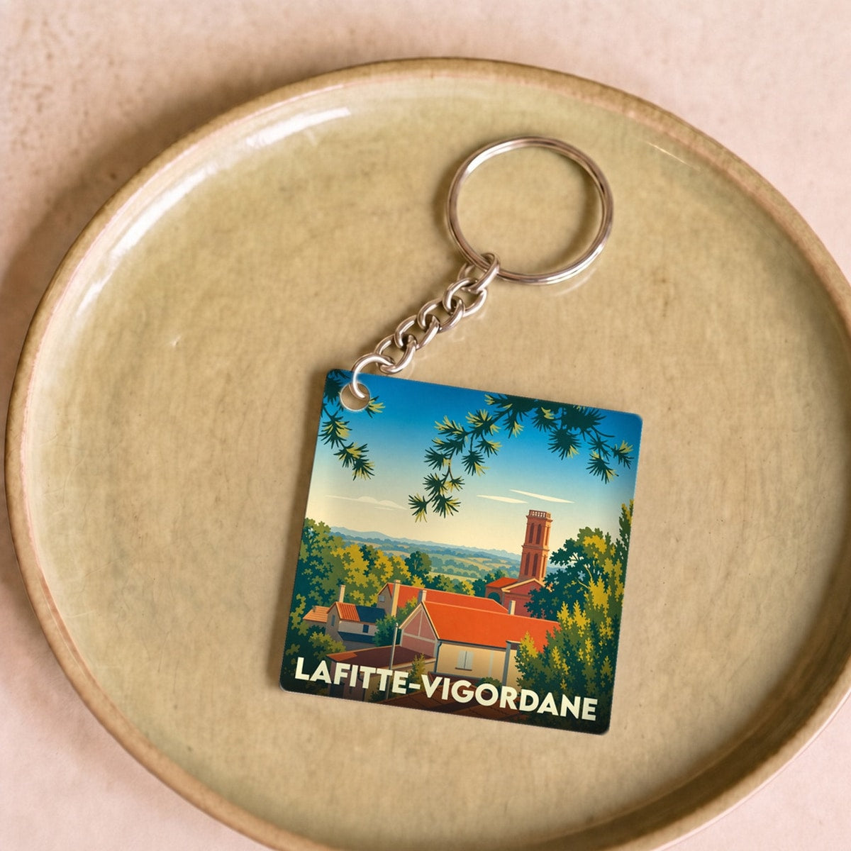 Porte-clés souvenir de la ville de Lafitte-Vigordane avec une illustration stylisée.