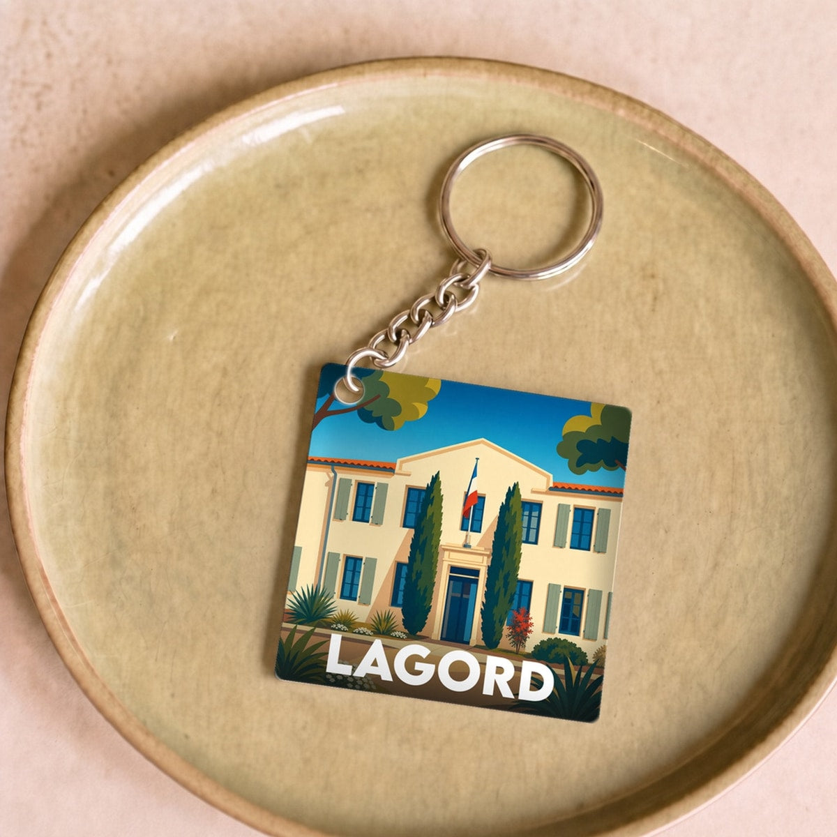 Porte-clés souvenir de la ville de Lagord avec une illustration stylisée d'une demeure traditionnelle.