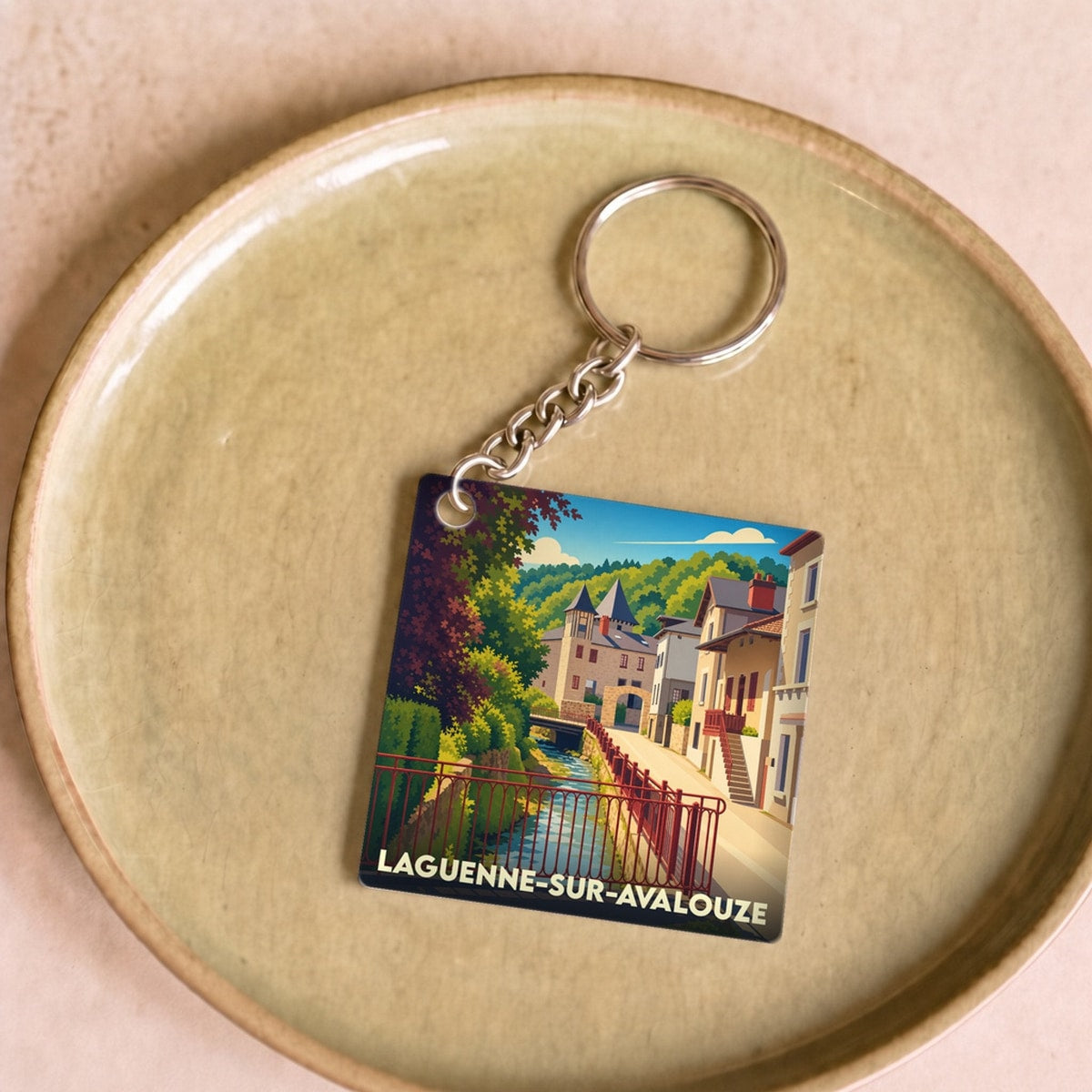 Porte-clés souvenir de la ville de Laguenne-sur-Avalouze avec une illustration stylisée.