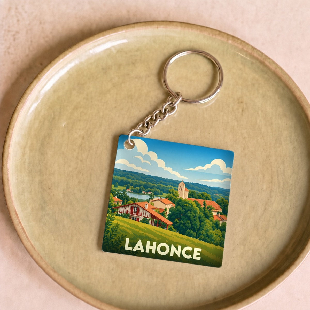 Porte-clés souvenir de la ville de Lahonce avec une illustration stylisée et colorée du paysage local.