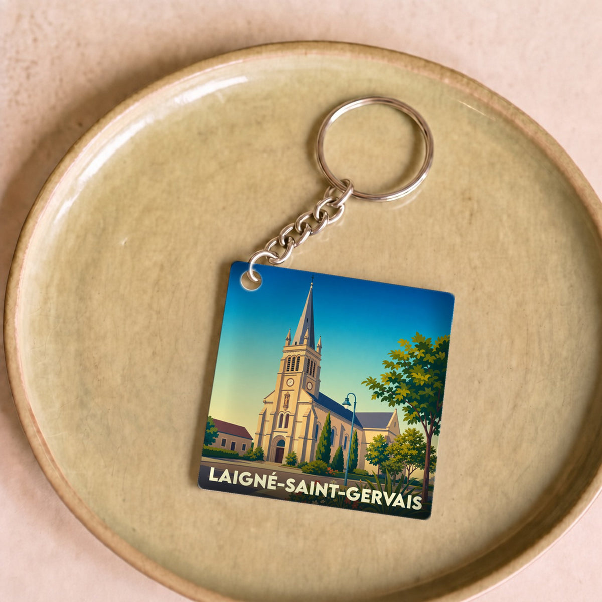 Porte-clés souvenir de la ville de Laigné-Saint-Gervais avec une illustration stylisée de son église.