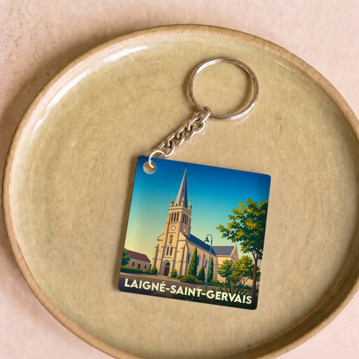 Porte-clés souvenir de la ville de Laigné-Saint-Gervais avec une illustration stylisée de son église.