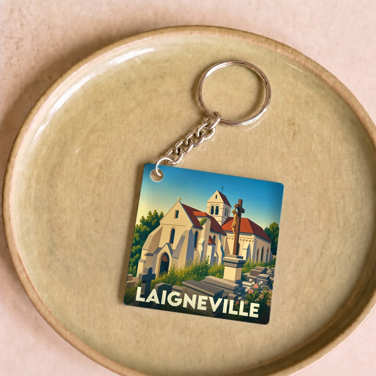 Porte-clés souvenir de la ville de Laigneville avec une illustration stylisée de son église et de son cimetière.
