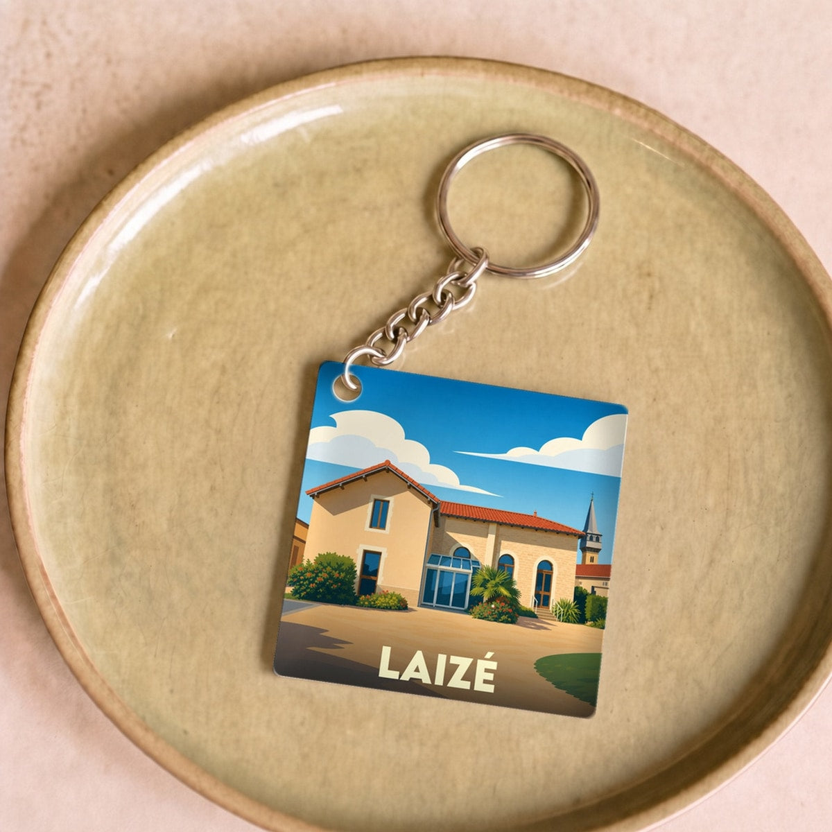 Porte-clés souvenir de la ville de Laizé avec une illustration stylisée.
