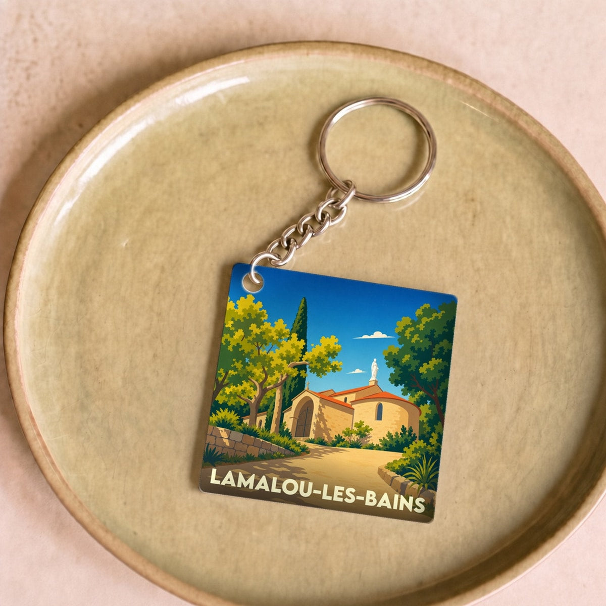 Porte-clés souvenir de la ville de Lamalou-les-Bains avec une illustration stylisée.