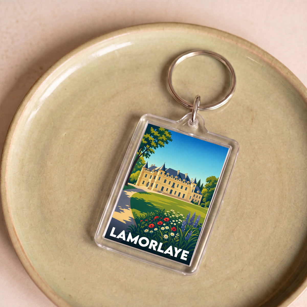 Porte-clés souvenir de la ville de Lamorlaye avec une illustration stylisée de son château.