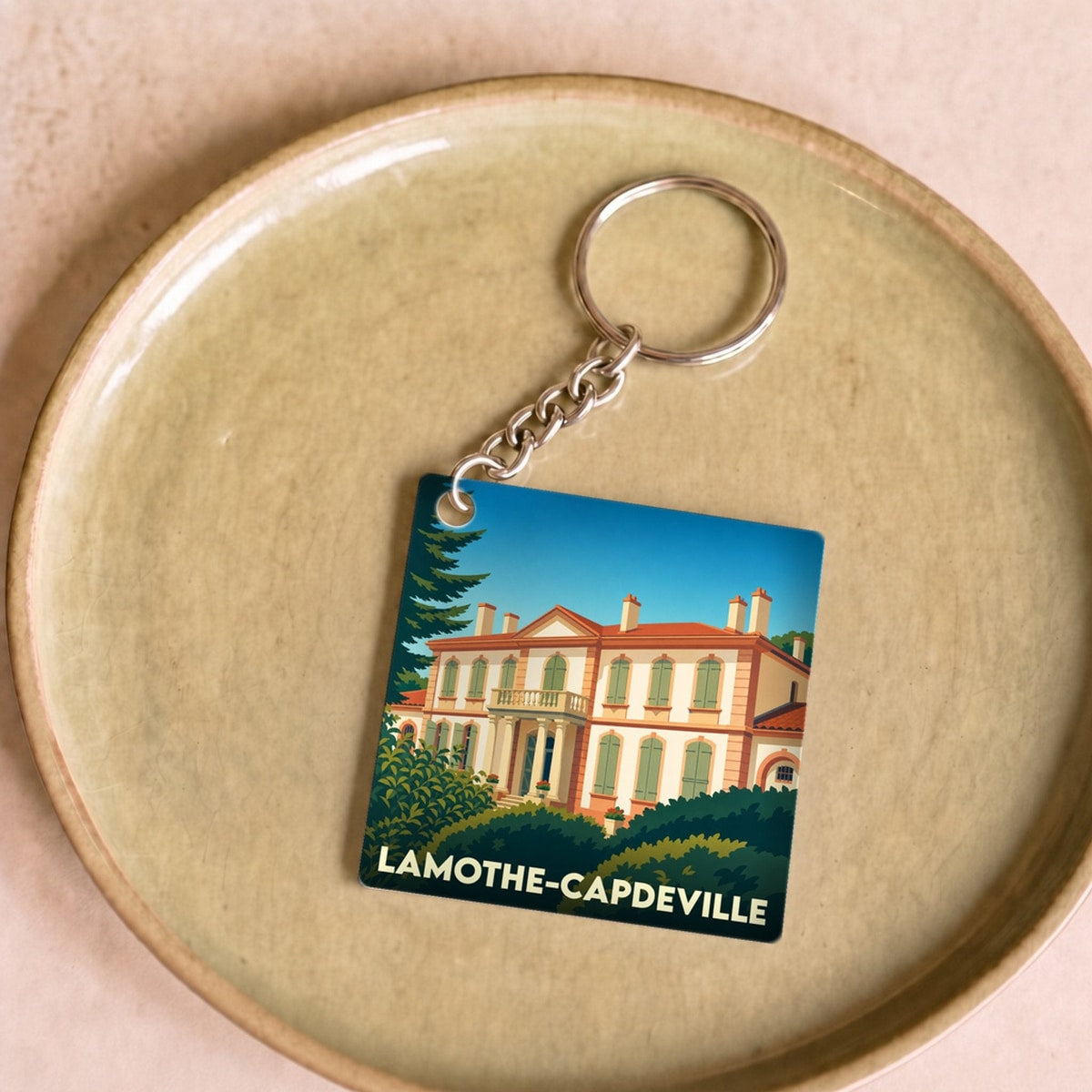 Porte-clés souvenir de la ville de Lamothe-Capdeville avec une illustration stylisée.
