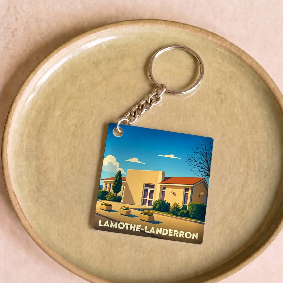 Porte-clés souvenir de la ville de Lamothe-Landerron avec une illustration stylisée.