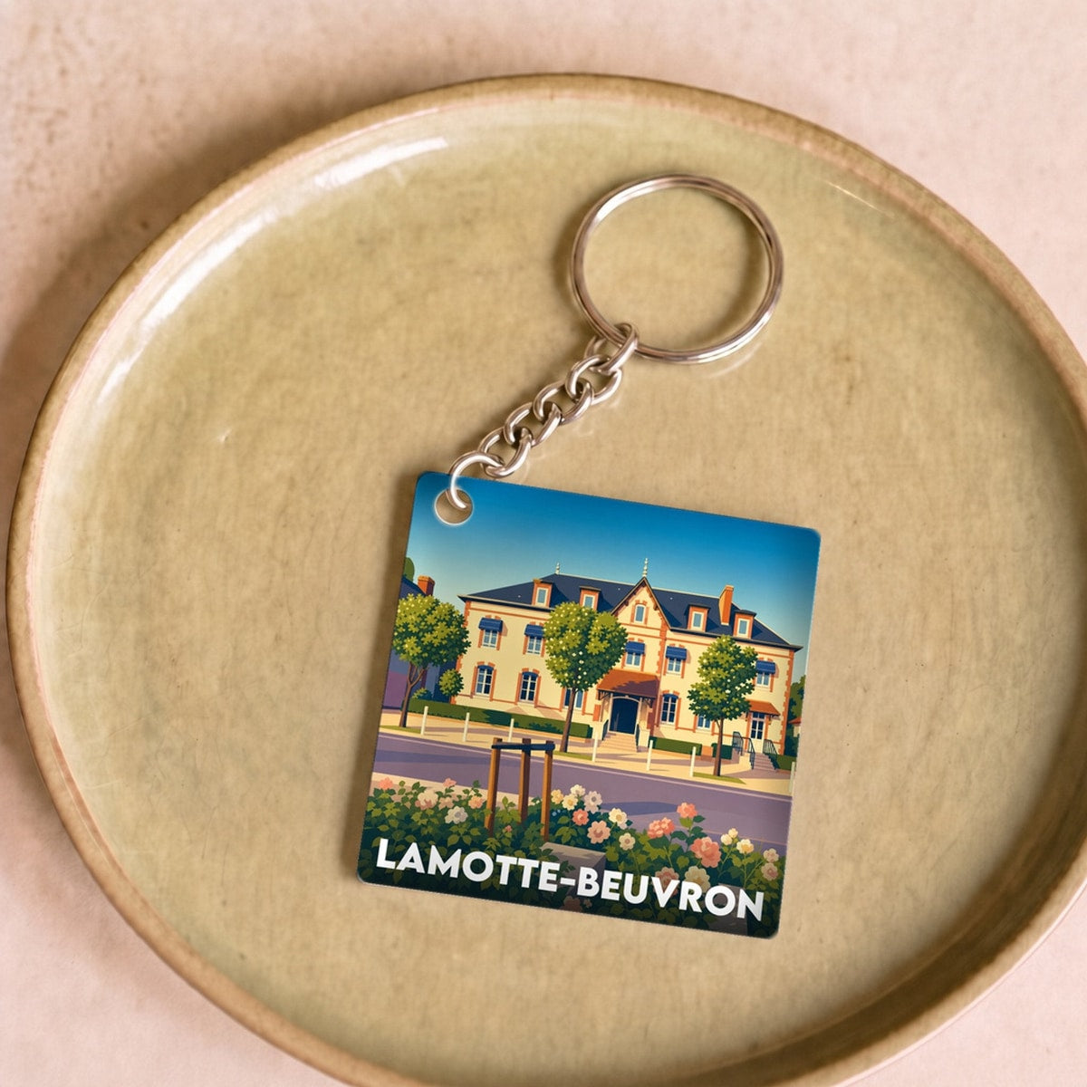 Porte-clés souvenir de la ville de Lamotte-Beuvron avec une illustration stylisée d'un bâtiment.