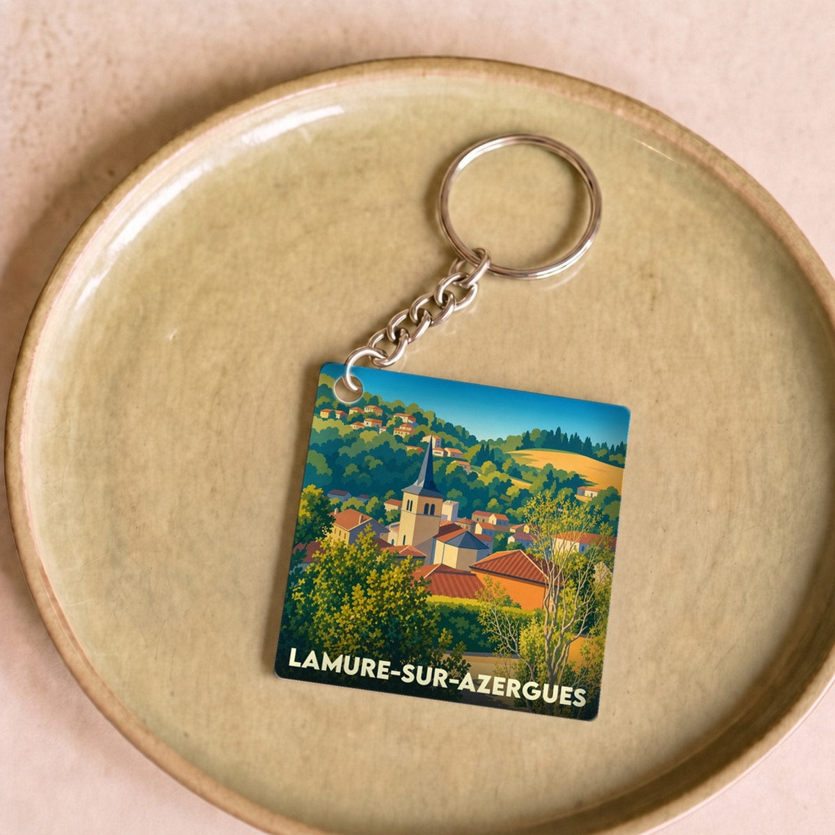 Porte-clés souvenir de la ville de Lamure-sur-Azergues avec une illustration stylisée.