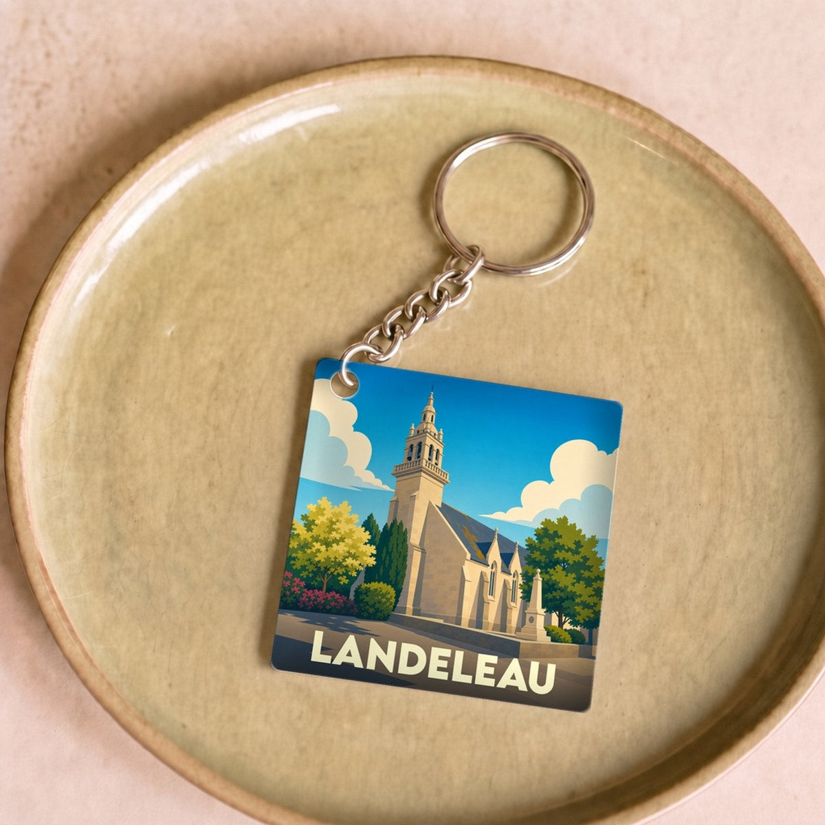 Porte-clés souvenir de la ville de Landeleau avec une illustration stylisée d'une église.
