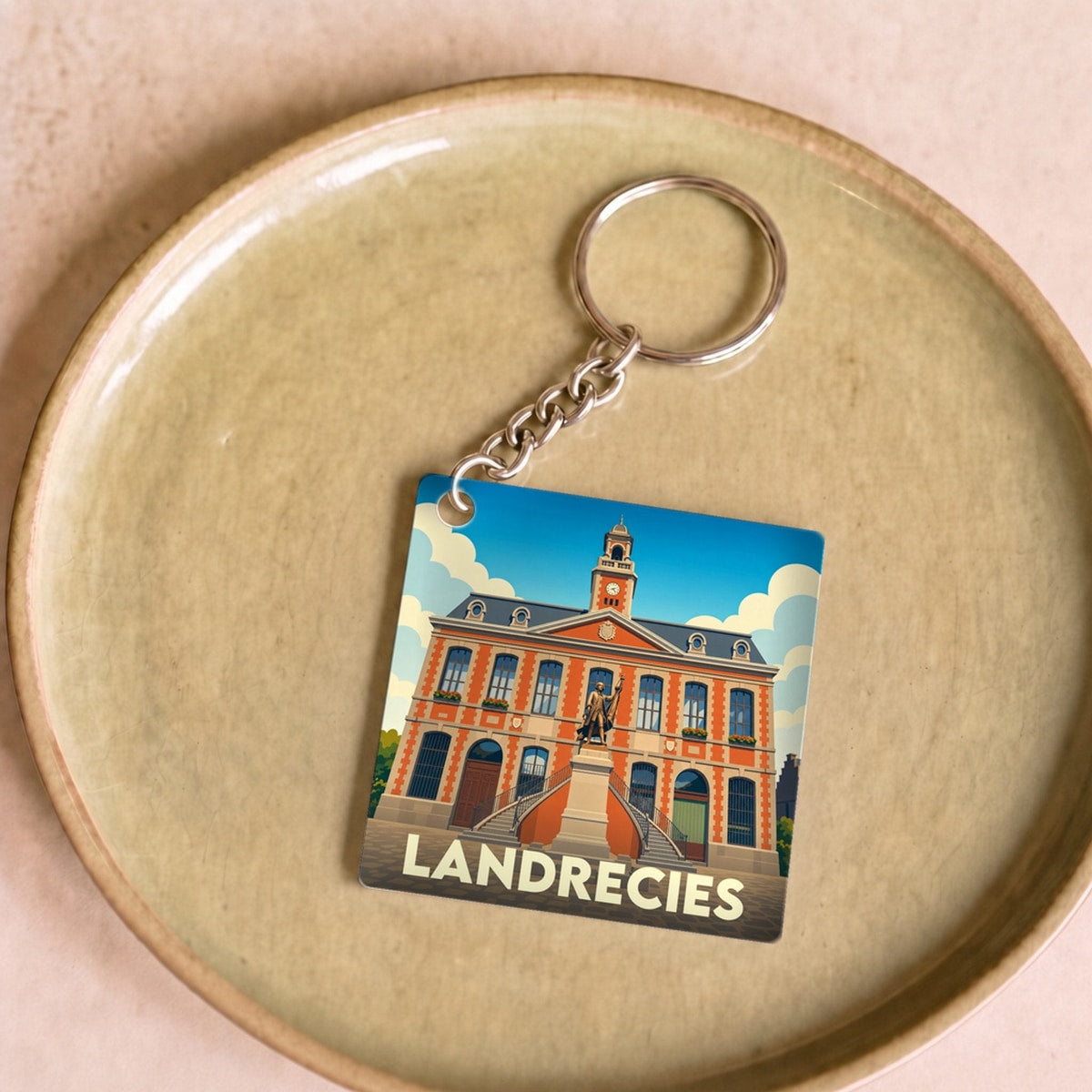 Porte-clés souvenir de la ville de Landrecies avec une illustration stylisée de son hôtel de ville.
