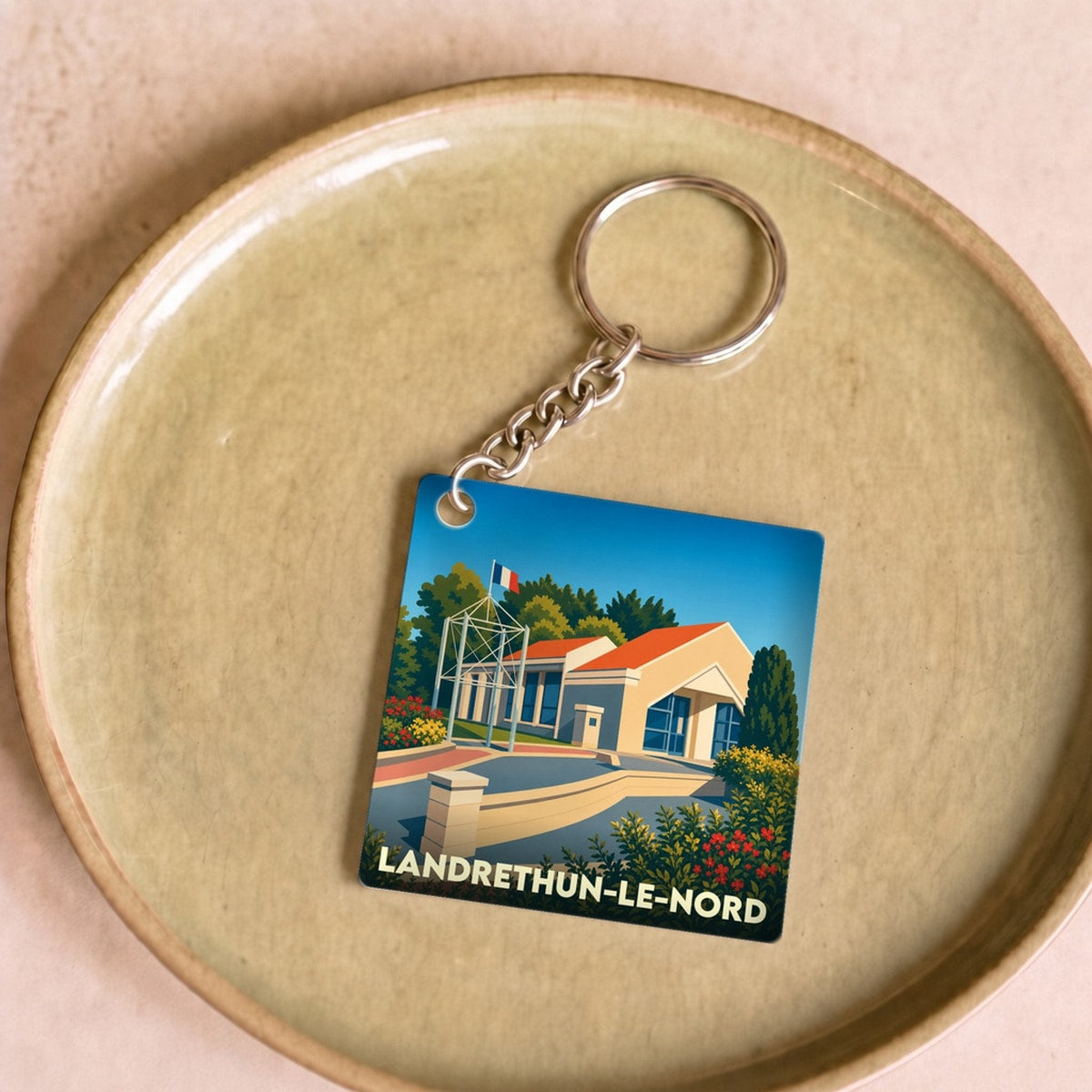 Porte-clés souvenir de la ville de Landrethun-le-Nord avec une illustration stylisée.