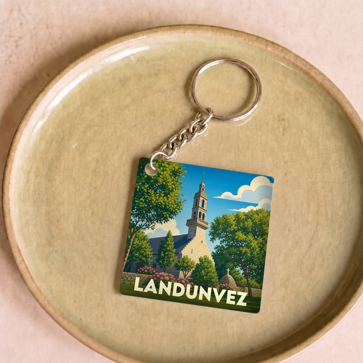 Porte-clés souvenir de la ville de Landunvez avec une illustration stylisée de son église.