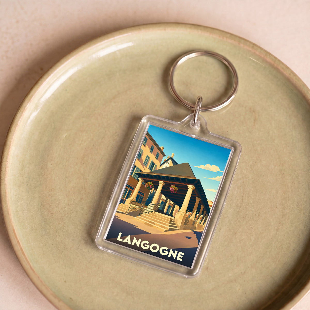 Porte-clés souvenir de la ville de Langogne avec une illustration stylisée de ses halles historiques.