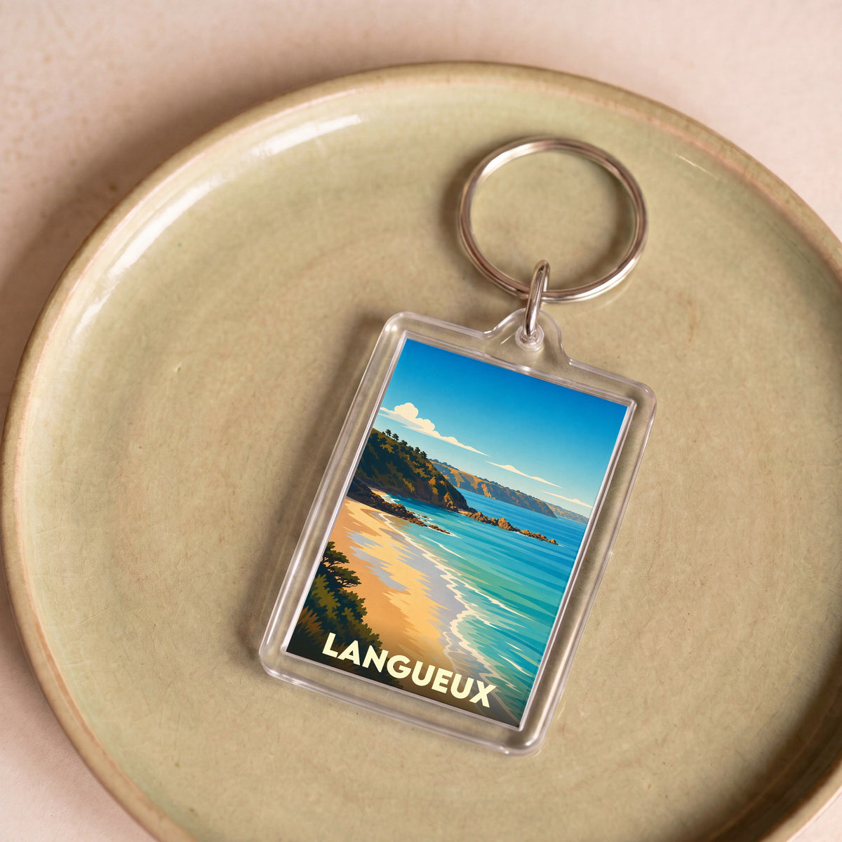 Porte-clés souvenir de la ville de Langueux avec une illustration stylisée d'un paysage côtier.