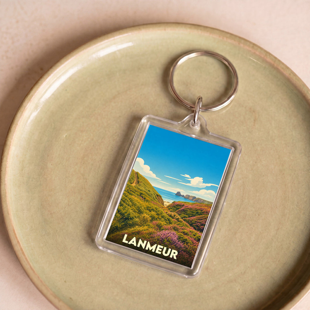 Porte-clés souvenir de la ville de Lanmeur avec une illustration de paysage côtier.