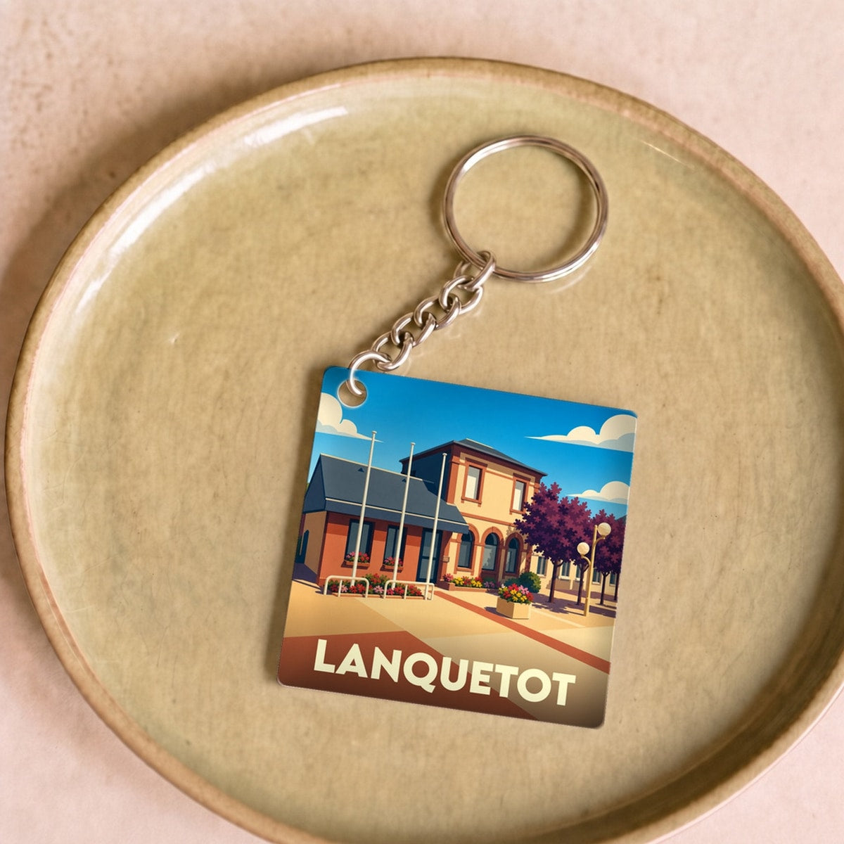 Porte-clés souvenir de la ville de Lanquetot avec une illustration stylisée.