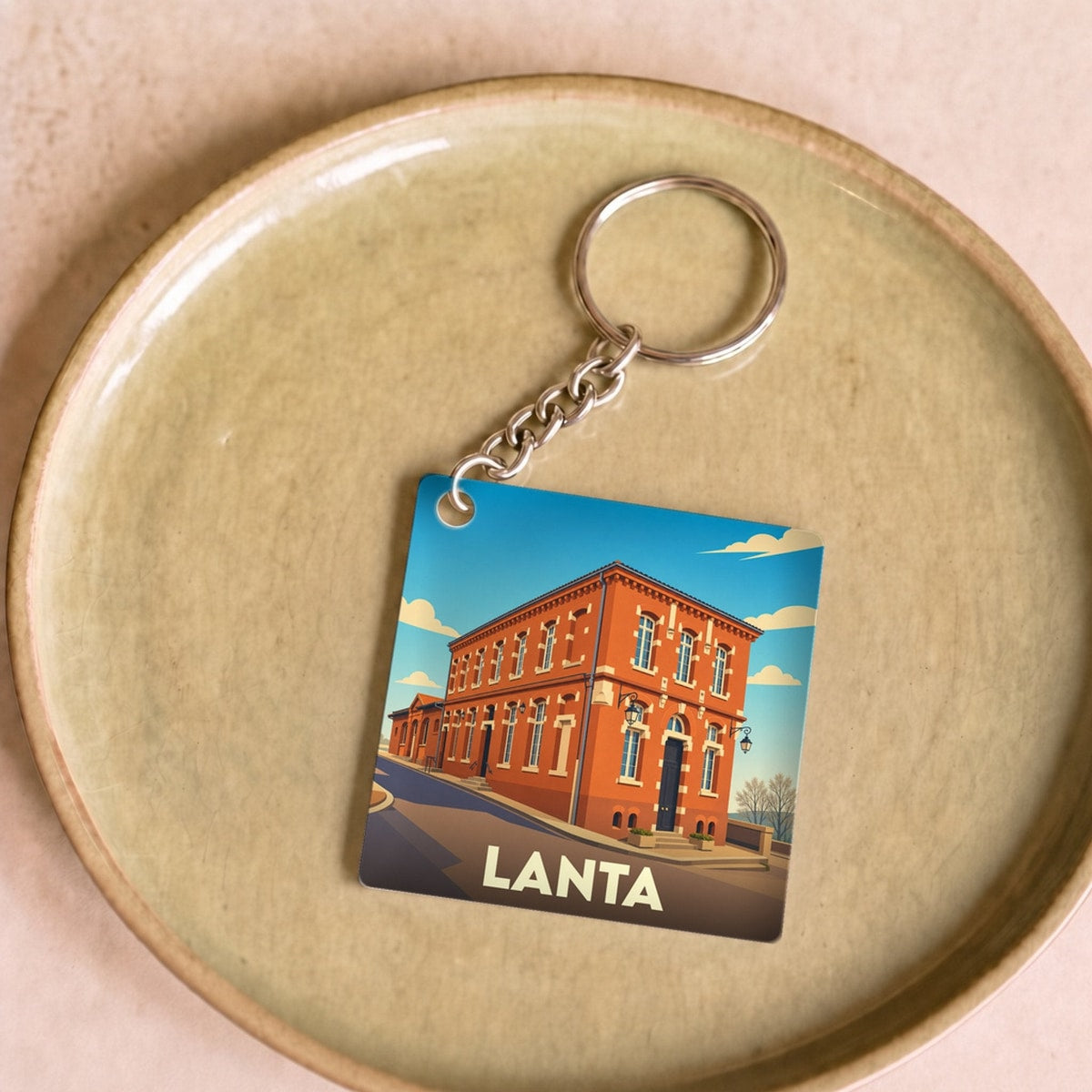 Porte-clés souvenir de la ville de Lanta avec une illustration stylisée.