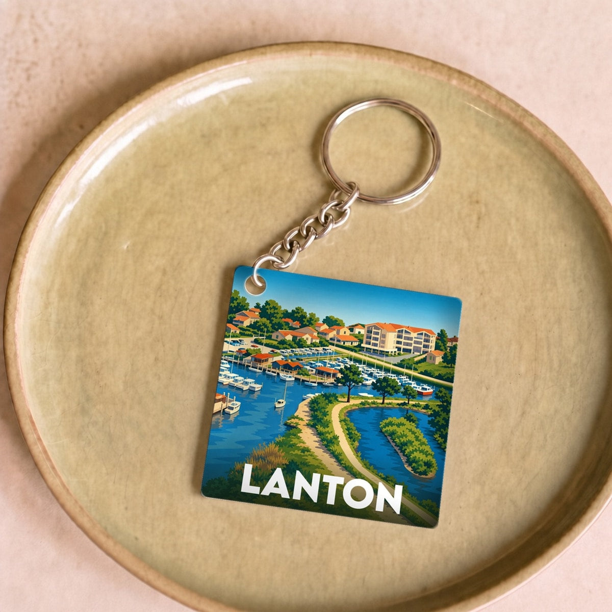 Porte-clés souvenir de la ville de Lanton avec une illustration stylisée du bassin.
