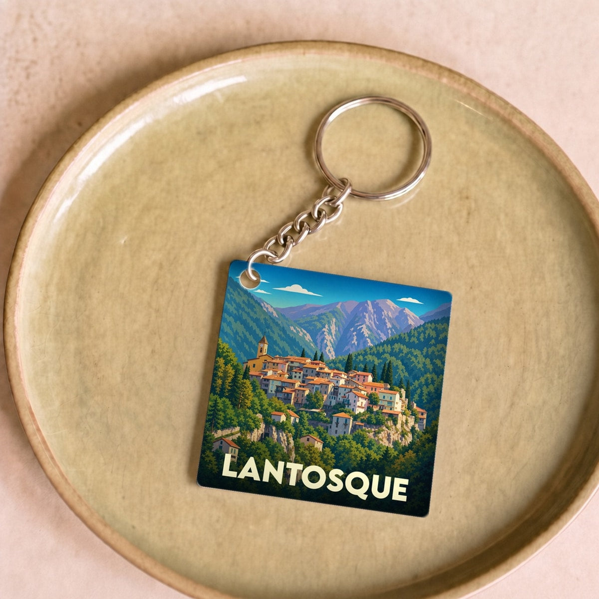 Porte-clés souvenir de la ville de Lantosque avec une illustration stylisée.