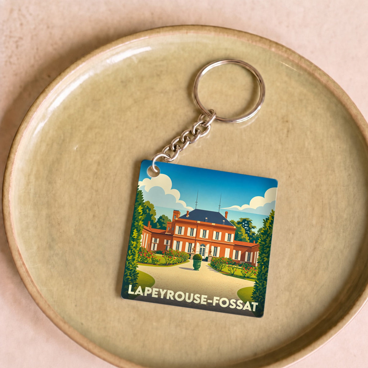 Porte-clés souvenir de la ville de Lapeyrouse-Fossat avec une illustration stylisée d'un château.