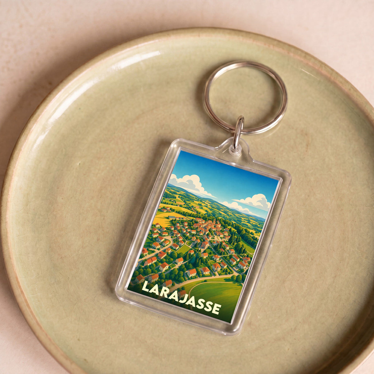 Porte-clés souvenir de la ville de Larajasse avec une illustration stylisée.