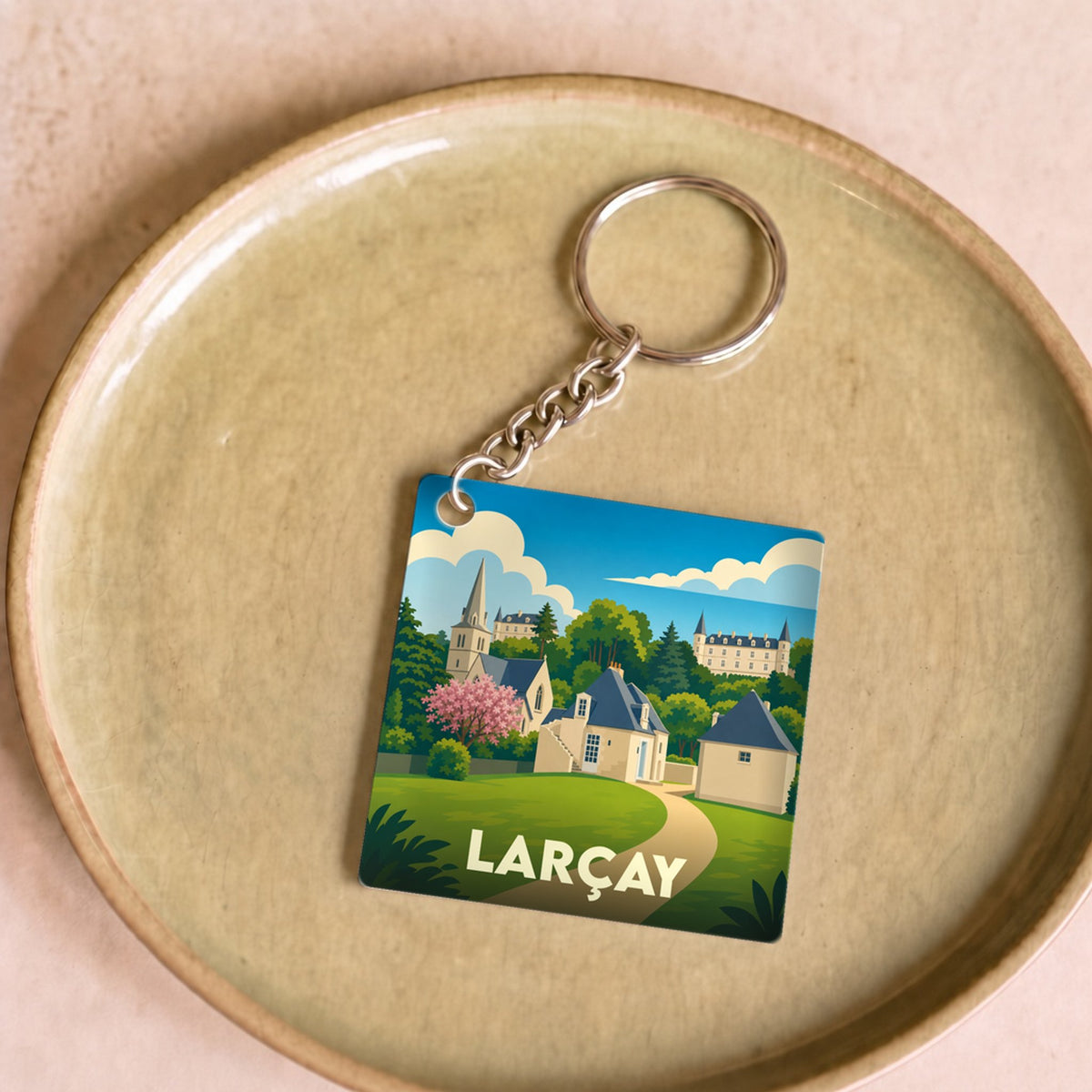 Porte-clés souvenir de la ville de Larçay avec une illustration stylisée de son paysage.